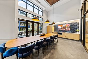 A conference room with a long table and blue chairs.